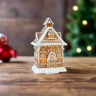 Decorative gingerbread house with a white roof on a white background